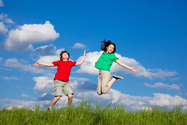 Chica y niño saltando, corriendo al aire libre — Foto de Stock