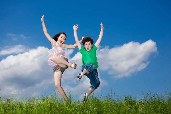 Meisje en jongen springen — Stockfoto