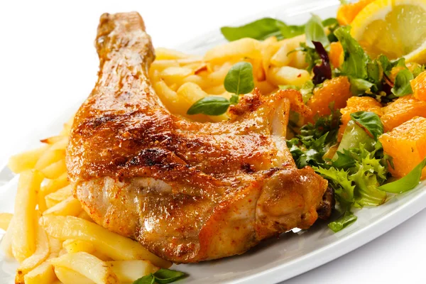 Жареная куриная ножка, картошка фри и овощи — стоковое фото