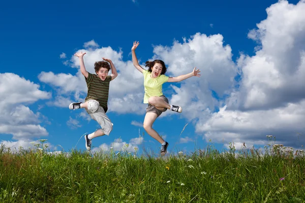 Kız ve oğlan açık atlama — Stok fotoğraf