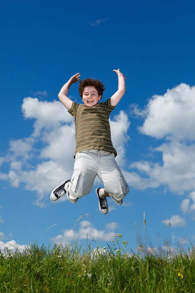 Boy jumping outdoors Stock Picture