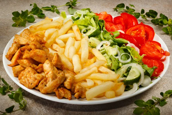 Carne grelhada com batatas fritas e salada de legumes — Fotografia de Stock