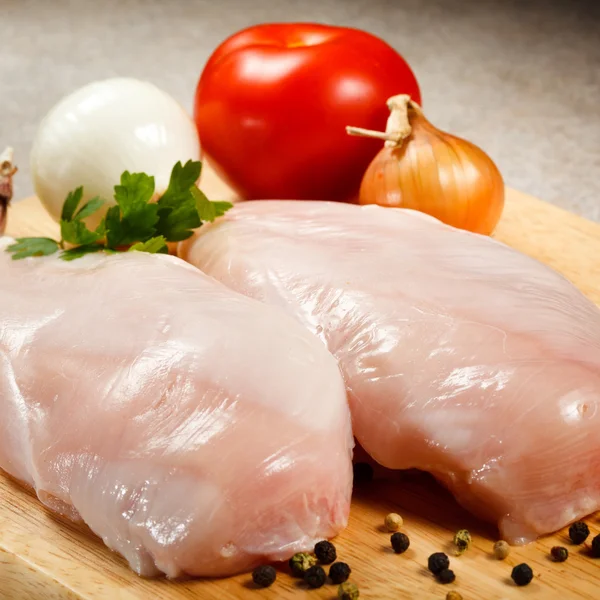 Poitrines de poulet cru sur planche à découper — Photo