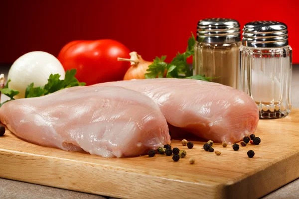 Raw chicken breasts on cutting board — Stock Photo, Image