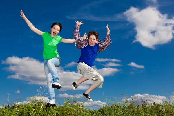 Chica y niño saltando, corriendo al aire libre —  Fotos de Stock