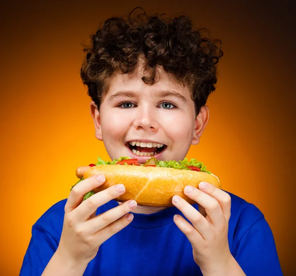 Menino comendo grandes sanduíches — Fotografia de Stock