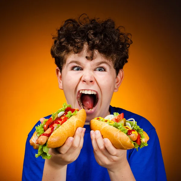 Το αγόρι τρώει μεγάλα σάντουιτς. — Φωτογραφία Αρχείου