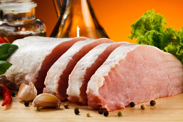 Raw pork on cutting board and vegetables — Stock Photo, Image