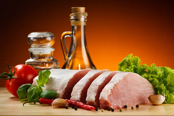 Raw pork on cutting board and vegetables — Stock Photo, Image