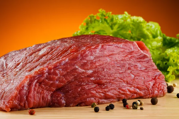 Raw beef on cutting board and black pepper — Stock Photo, Image