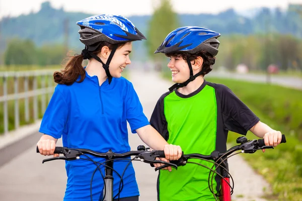 Chica y niño en bicicleta — Foto de Stock