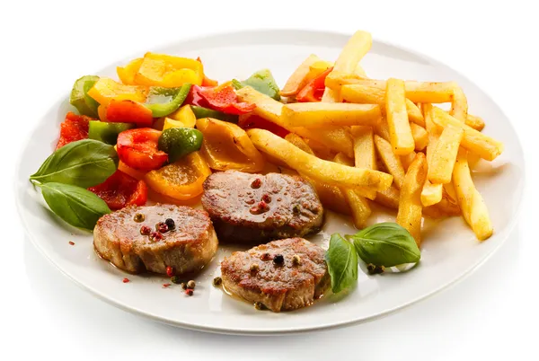 Grilled steaks, French fries and vegetables — Stock Photo, Image