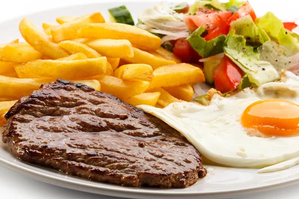 Steaks vom Grill, Pommes frites, Spiegelei und Gemüse — Stockfoto