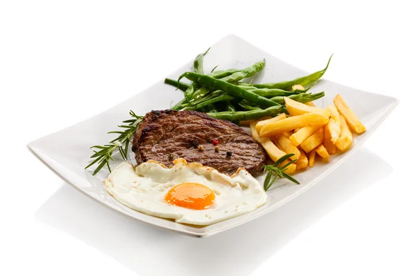 Steaks vom Grill, Pommes frites, Spiegelei und Gemüse — Stockfoto