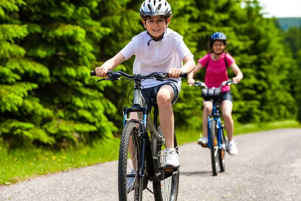 Flicka och pojke cykling — Stockfoto