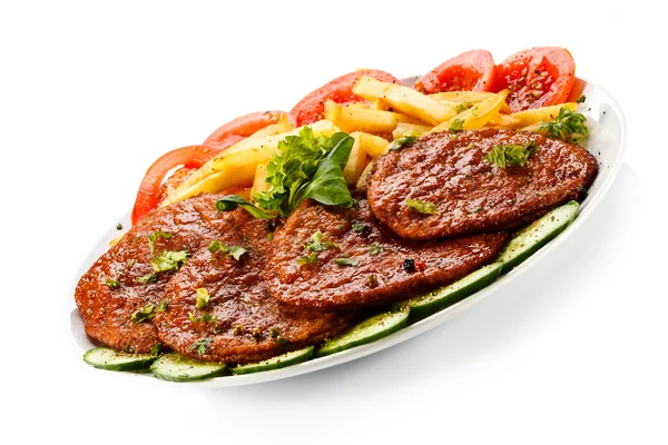 Grilled steaks, French fries and vegetables — Stock Photo, Image