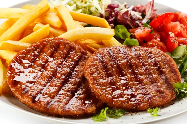Gegrilde steaks, Franse frietjes en groenten — Stockfoto