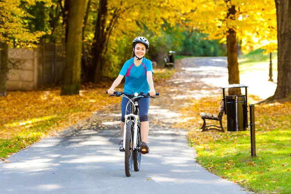 Girl biking in city park — Stock Photo, Image