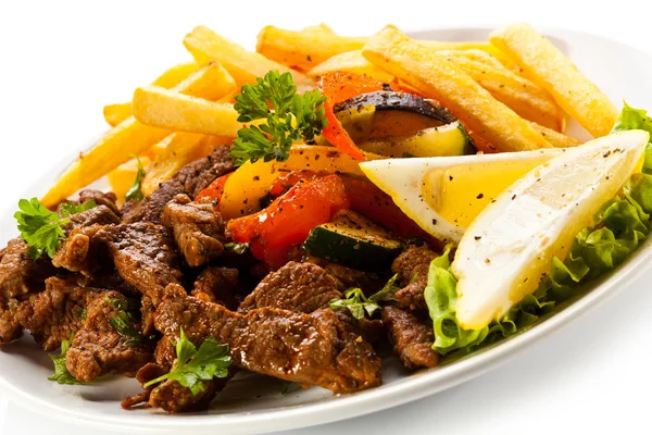Roasted meat, French fries and vegetables — Stock Photo, Image
