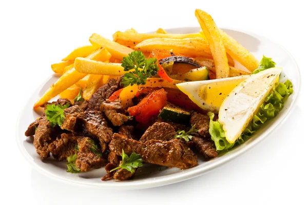 Roasted meat, French fries and vegetables — Stock Photo, Image