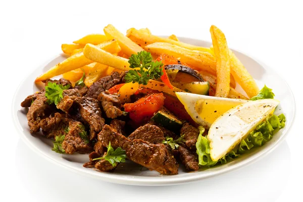 Roasted meat, French fries and vegetables — Stock Photo, Image