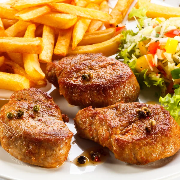 Gegrilde steaks, Franse frietjes en groenten — Stockfoto
