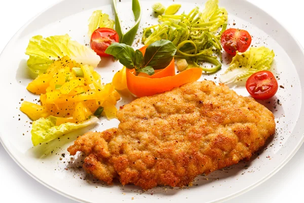 Côtelettes de porc frites, pommes de terre cuites au four et salade de légumes — Photo