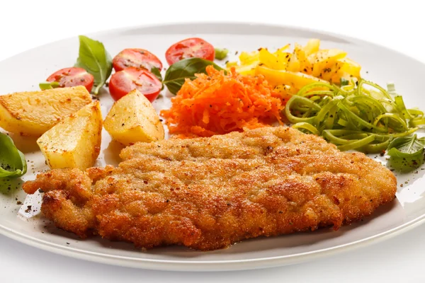 Gebratene Schweinekoteletts, Bratkartoffeln und Gemüsesalat — Stockfoto