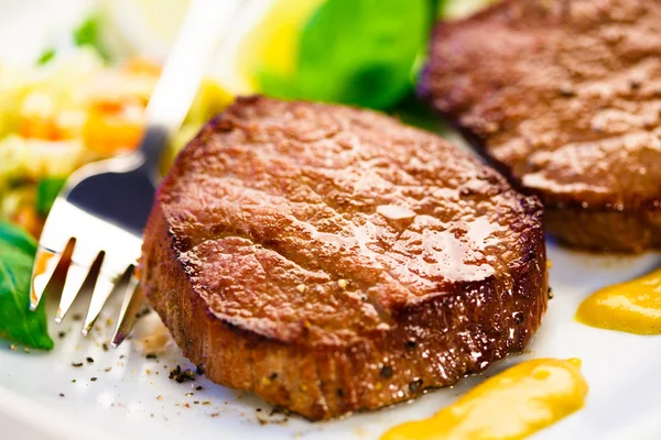 Grilled steaks and vegetable salad — Stock Photo, Image