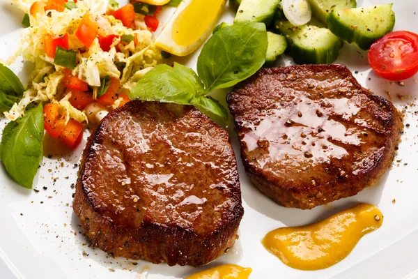 Grilled steaks and vegetable salad — Stock Photo, Image