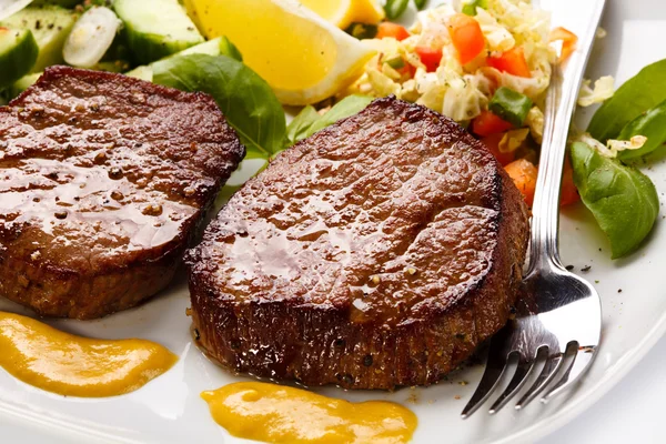 Grilled steaks and vegetable salad — Stock Photo, Image