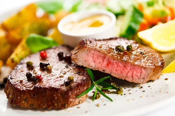 Grilované steaky, pečené brambory a zeleninový salát — Stock fotografie