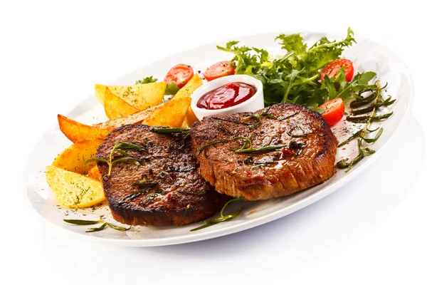 Grilled steaks, baked potatoes and vegetable salad — Stock Photo, Image