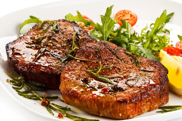 Grilled steaks and vegetable salad — Stock Photo, Image