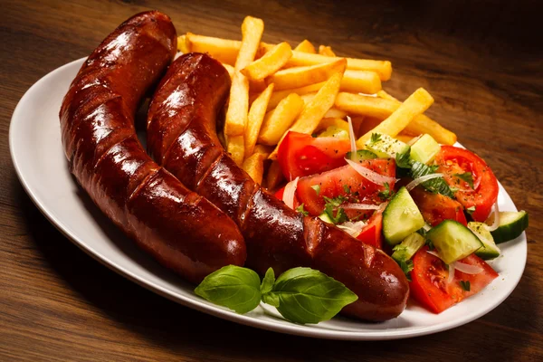 Embutidos a la parrilla con patatas fritas y verduras — Foto de Stock