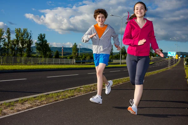 Nastoletnia dziewczynka i chłopiec biegną — Zdjęcie stockowe