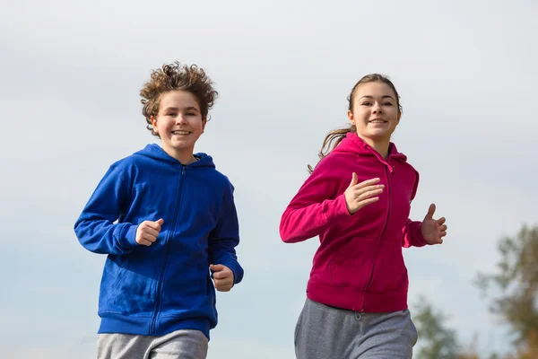 Девочка и мальчик-подросток бегут — стоковое фото