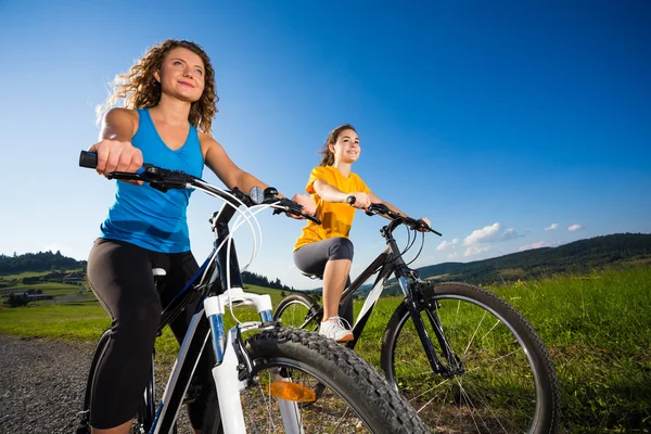 Dos mujeres jóvenes en bicicleta — Foto de Stock