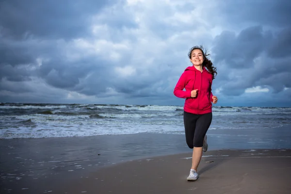 Flicka kör på stranden — Stockfoto