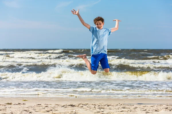 Ragazzo saltare sulla spiaggia — Foto Stock