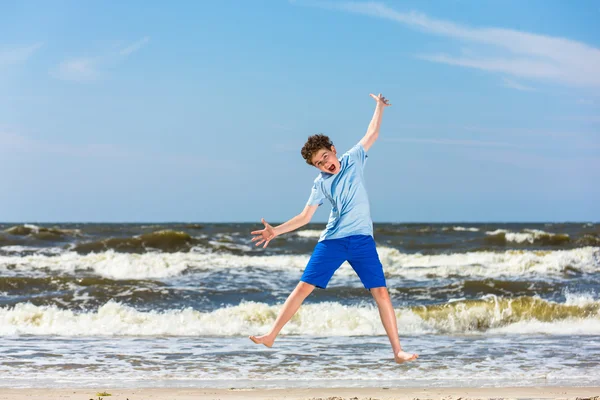 Niño saltando en la playa — Foto de Stock