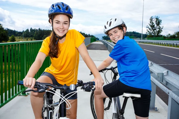 Adolescent fille et garçon équitation vélos — Photo