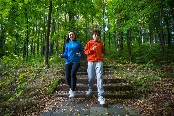 Девочка и мальчик-подросток бегут — стоковое фото