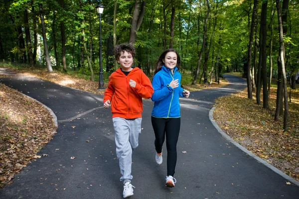 Adolescente chica y chico corriendo — Foto de Stock