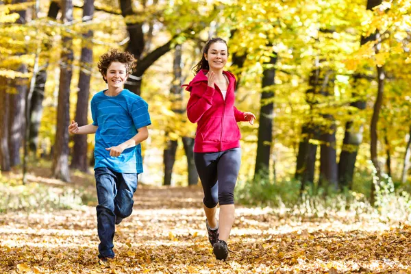 Teenage girl and boy running — Stock Photo, Image