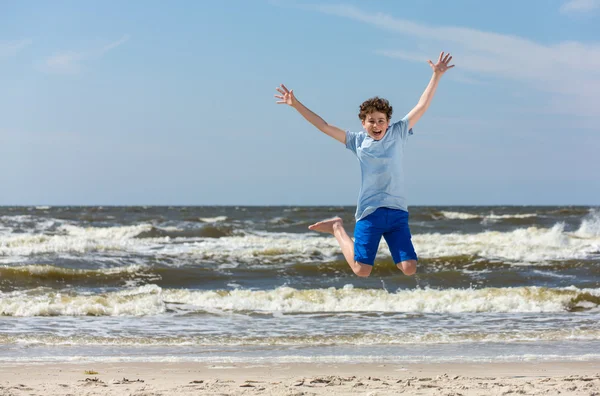 Rapaz saltando na praia — Fotografia de Stock