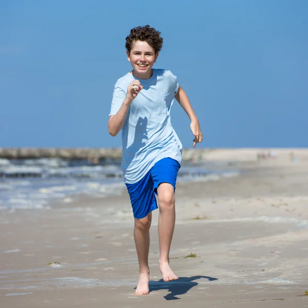 Pojke kör på stranden — Stockfoto