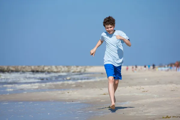 Pojke kör på stranden — Stockfoto