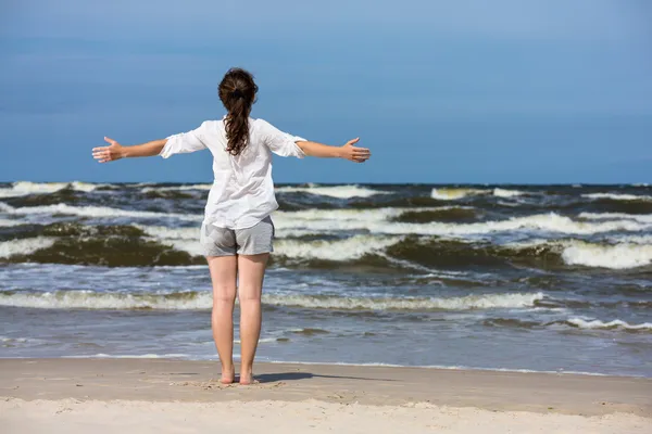 Mujer de pie en la playa — Foto de Stock