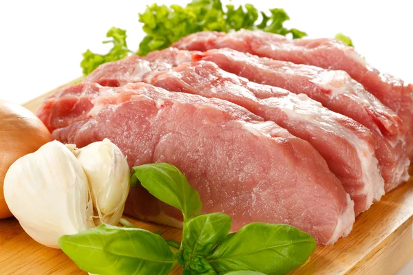 Raw pork chops on cutting board Stock Photo
